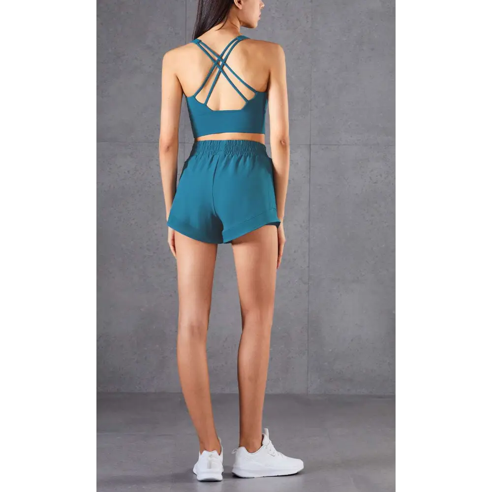 Teal mesh pockets fitness two-piece athletic set with strappy back bra top and high-waisted breathable fitness pants