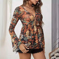 A woman wears a sheer floral romper with knotted flare sleeves and mesh printed long sleeves in v-neckline design