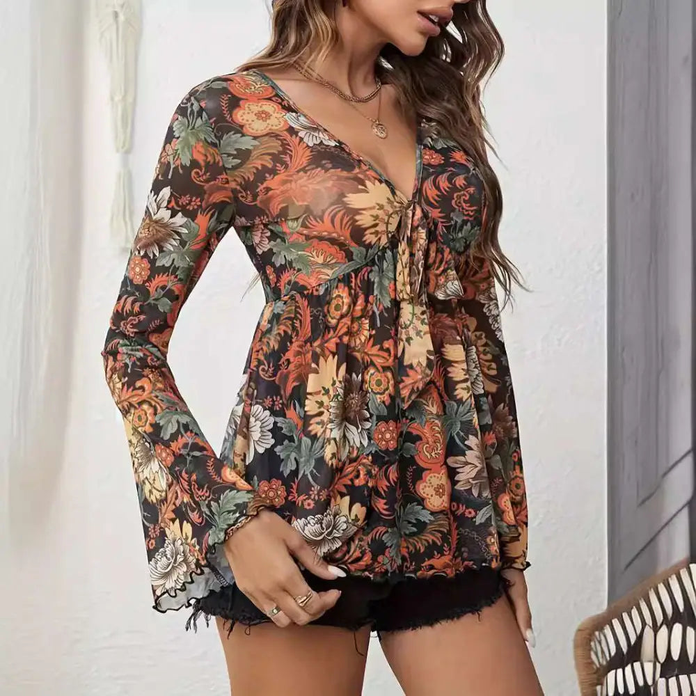 A woman wears a sheer floral romper with knotted flare sleeves and mesh printed long sleeves in v-neckline design