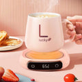 Pink ceramic mug with black lucky logo on a pink milk heating insulation base desktop digital display showing 65°c