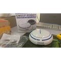 White and blue circular mini desktop robot vacuum with sleek modern design for efficient desktop cleaning tasks
