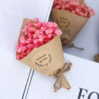 A delicate vibrant pink dried flower bouquet wrapped in rustic kraft paper and twine for home decoration gift box