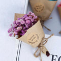 A delicate mini dried flower bouquet gift box featuring baby’s breath wrapped in brown kraft paper for home decoration