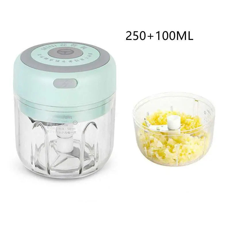 Mini electric garlic chopper in mint green with clear detachable glass bowl and stainless steel blade containing chopped food
