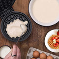 Black mini electric waffle maker with non-stick cooking surface and grid pattern for easy waffle preparation