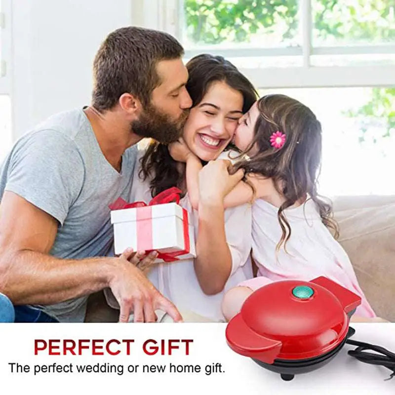 Mini electric waffle maker in red and black with a green power button and non-stick cooking surface for easy waffle preparation