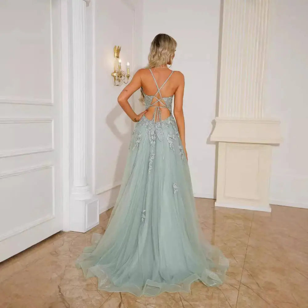 Mint green lace evening dress with flowing tulle, intricate silver beading, floral embroidery, and crisscross back design