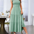 A soft mint green tiered midi dress with a fitted bodice and pleated layered hem perfect for elegant occasions
