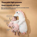 A soft white plush unicorn baby sleeper with pink stars shown alongside a mint green plush dinosaur baby pillow
