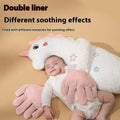 Soft white unicorn-shaped baby pillow with pink accents and stars alongside a mint green plush dinosaur baby pillow