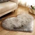 A plush heart shaped living room rug in soft gray faux fur texture designed as a mint green plush accent piece