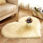 Cream-colored plush heart shaped living room rug with small floral arrangement on mint green plush background