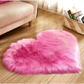 A plush heart shaped living room rug in vibrant pink with soft faux fur texture for cozy home decor