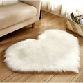 White fluffy heart shaped living room rug with soft faux fur texture complementing mint green plush decor