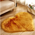 Golden-orange faux fur heart shaped rug complementing a mint green plush heart shaped living room rug setting