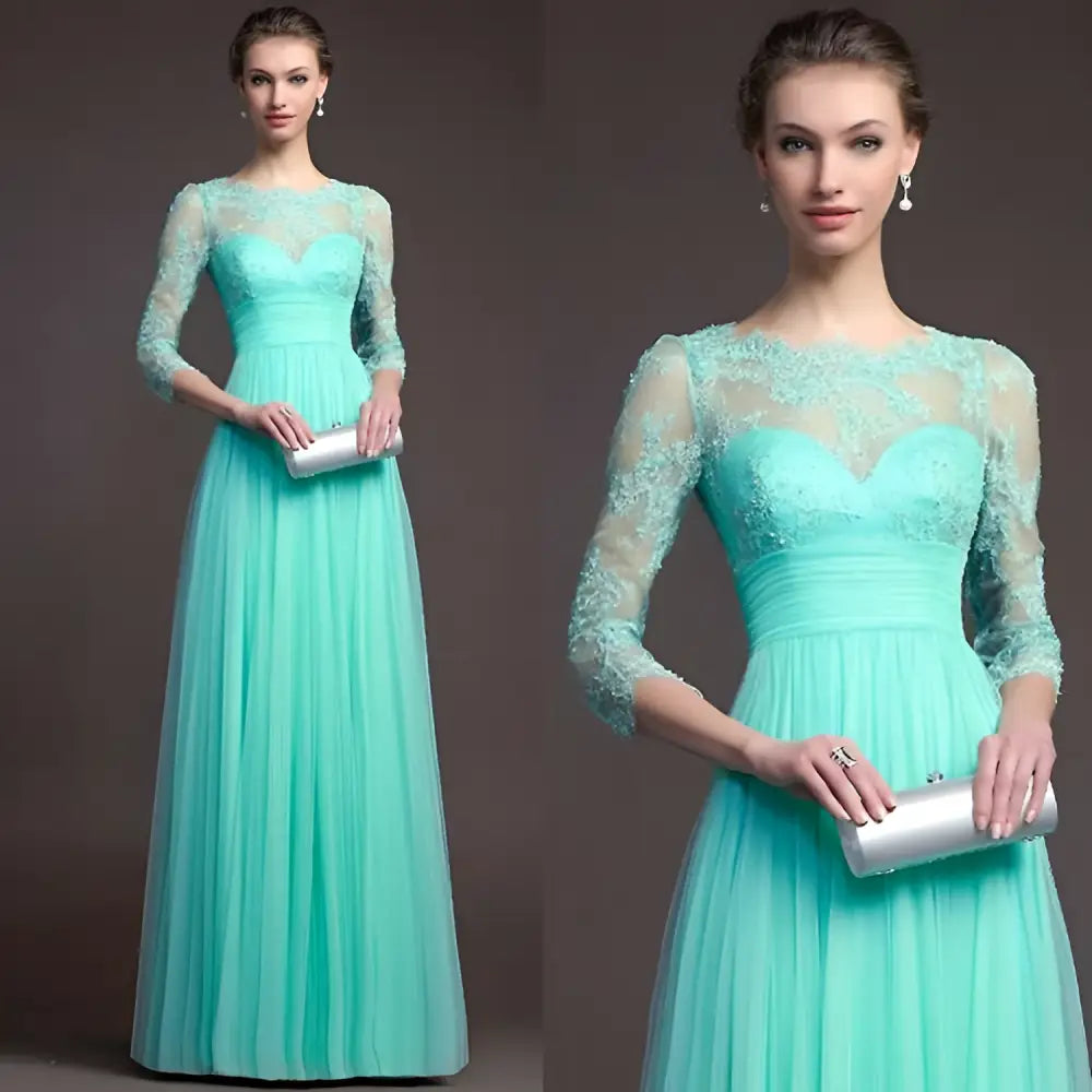 A woman wearing a mint green long sleeve lace gown with embroidered bodice and flowing tulle skirt