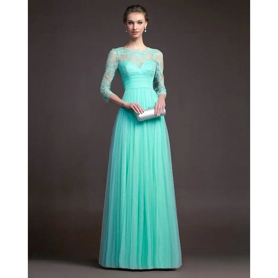 A woman wears a mint green long sleeve lace gown with three-quarter sleeves and a flowing skirt holding a silver clutch