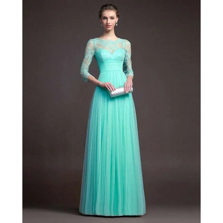 A woman wears a mint green long sleeve lace gown with a flowing tulle skirt featuring three-quarter sleeves