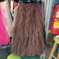 A layered brown tulle skirt with ruffled tiers highlighting mesh stitching detail on a rack for mint green tiered style