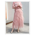 A flowing layered pink tulle skirt with mesh stitching and ruffled hemline complements the mint green tiered mesh skirt