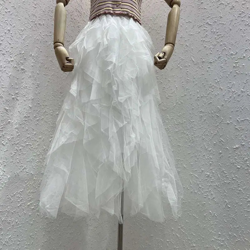 A flowing white tulle skirt with multiple ruffled layers displayed on a wooden mannequin for mint green tiered mesh stitching