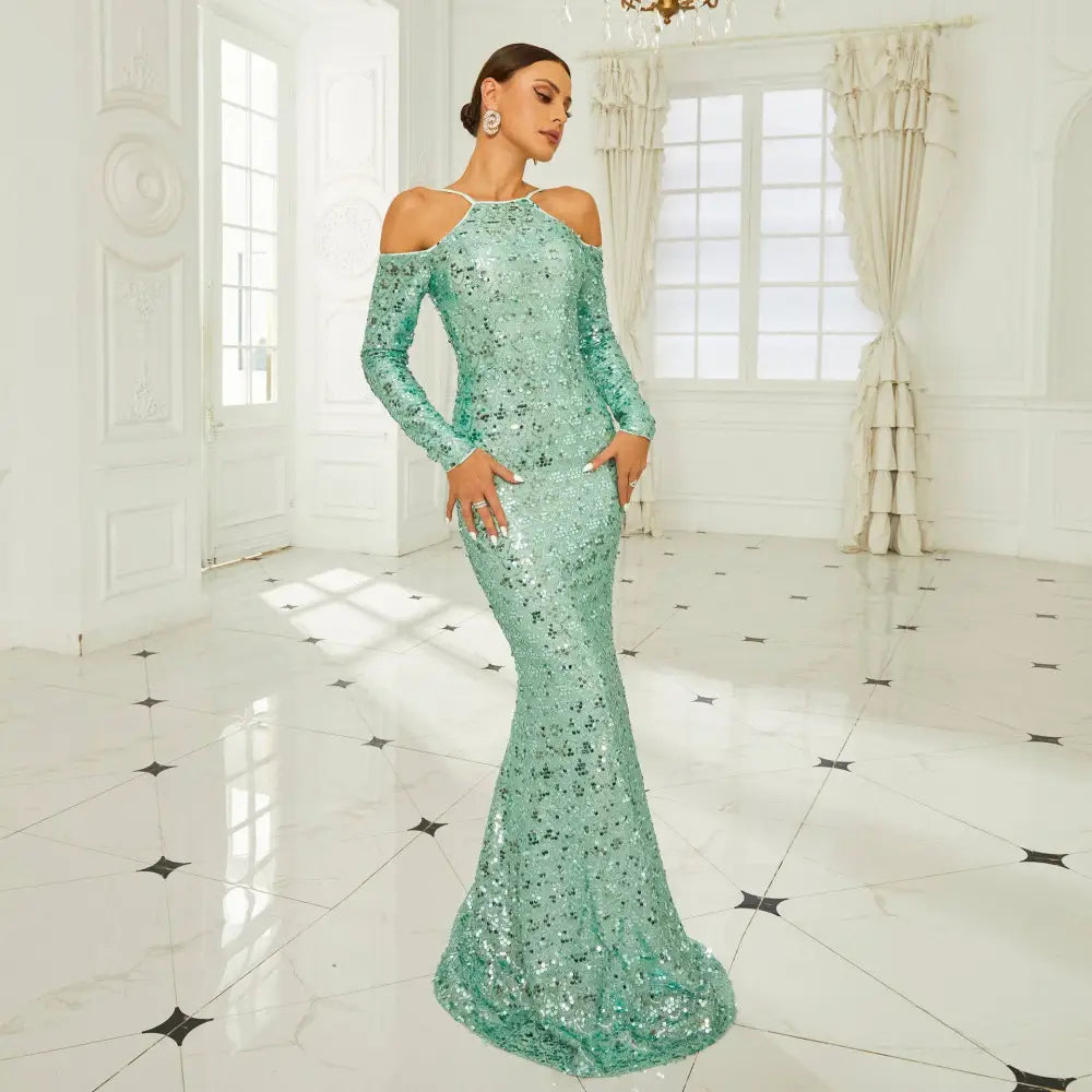 A shimmering mint green sequined sheath fishtail dress with long sleeves and an off-the-shoulder neckline