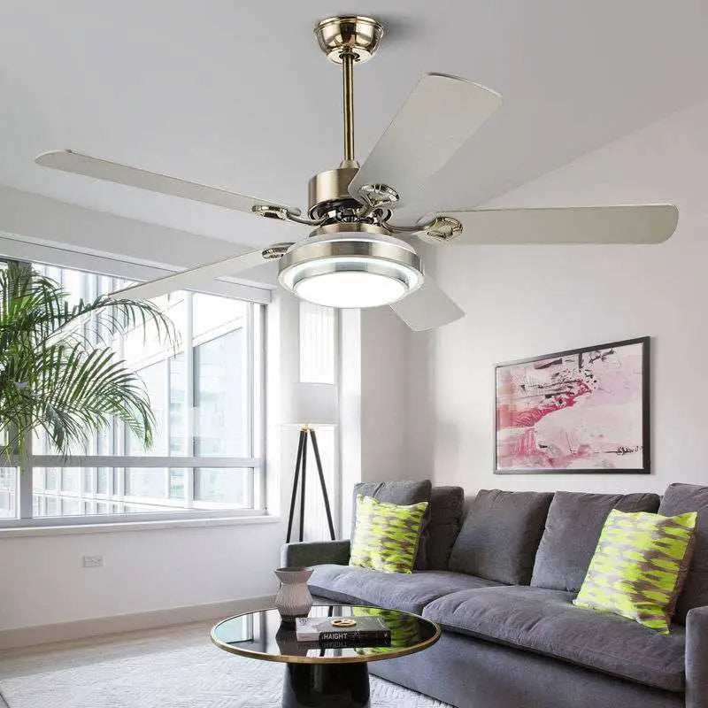 A modern home dining ceiling fan light with brushed brass finish, five white blades, and integrated circular led light