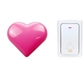 A glossy pink heart-shaped button on a modern white and silver wireless door bell for home use