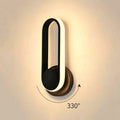 Modern white oval bedroom wall lamp with a sleek black and white led oval bedside bedroom design