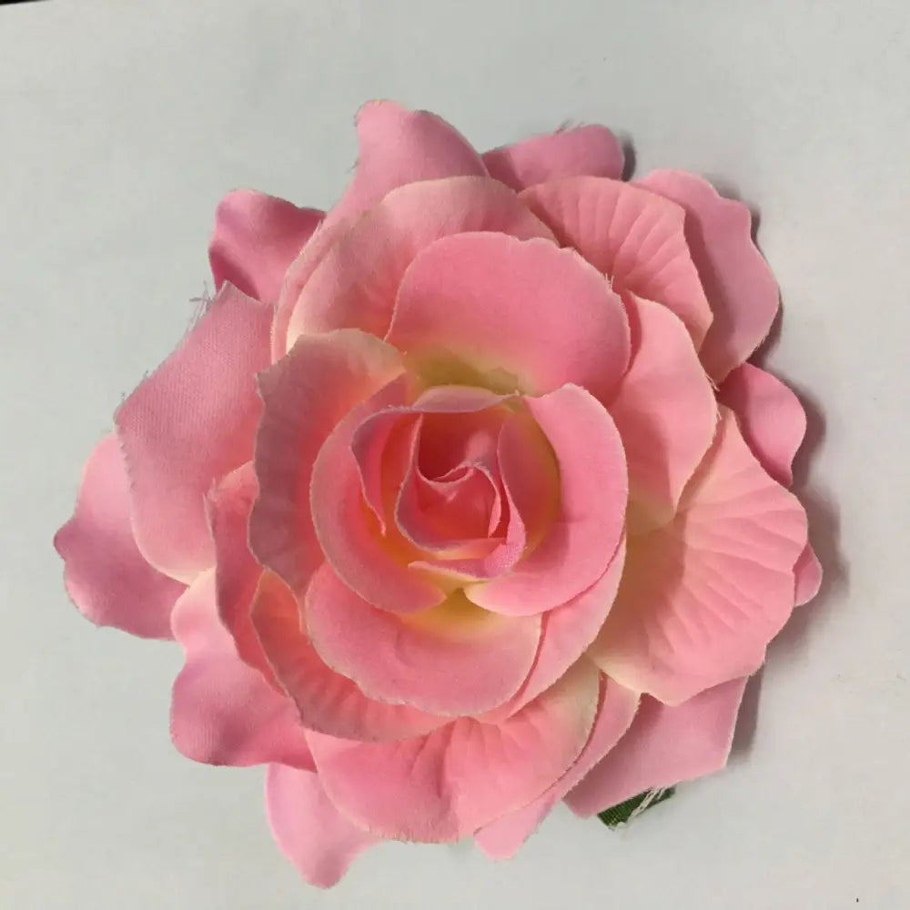 A delicate pink artificial rose with layered petals in a multicolor red roses flocking cloth headdress hairpin
