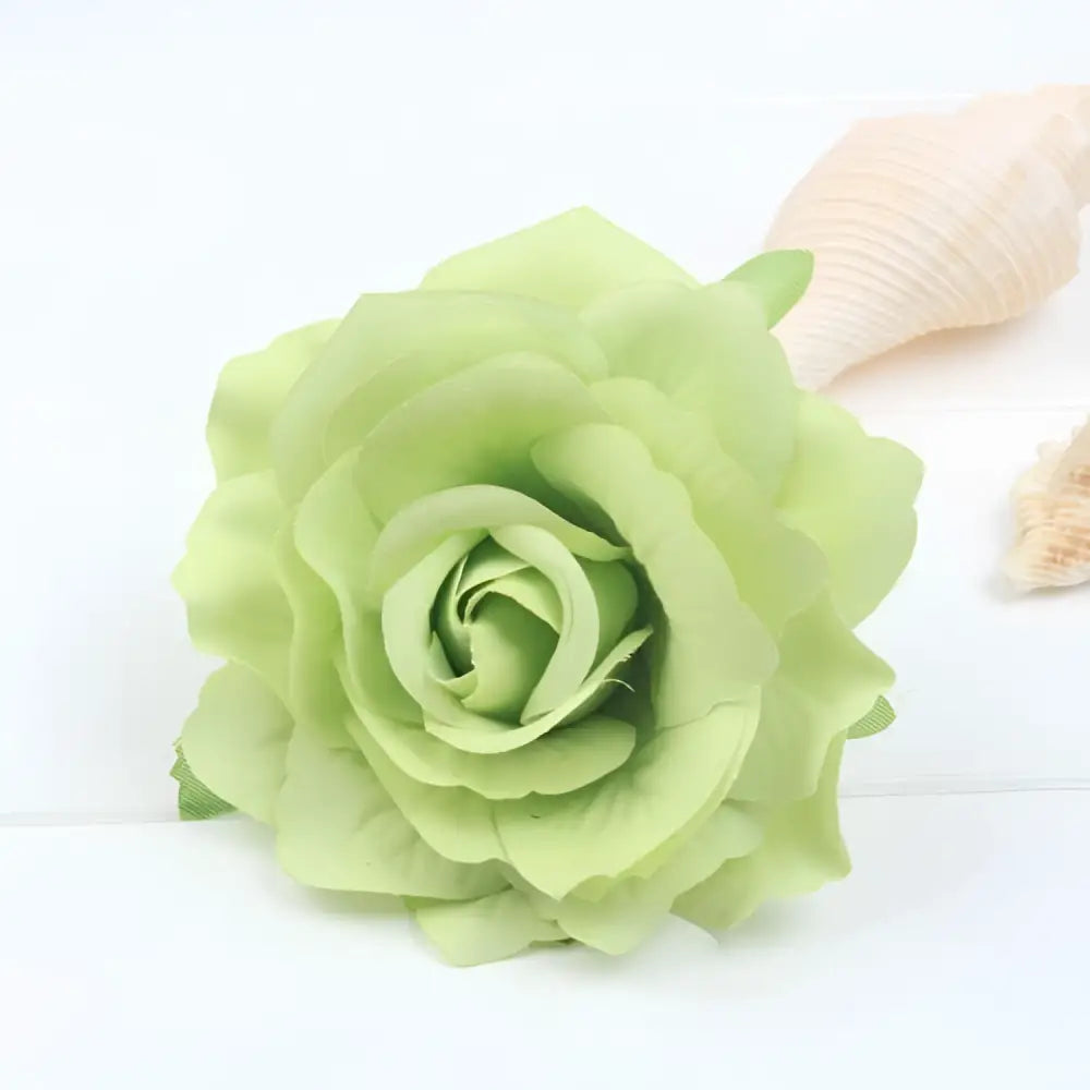 A delicate light green fabric rose with translucent petals in a multicolor red roses flocking cloth headdress hairpin