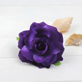 A deep purple artificial rose with layered petals and green leaves in a multicolor red roses flocking cloth headdress hairpin