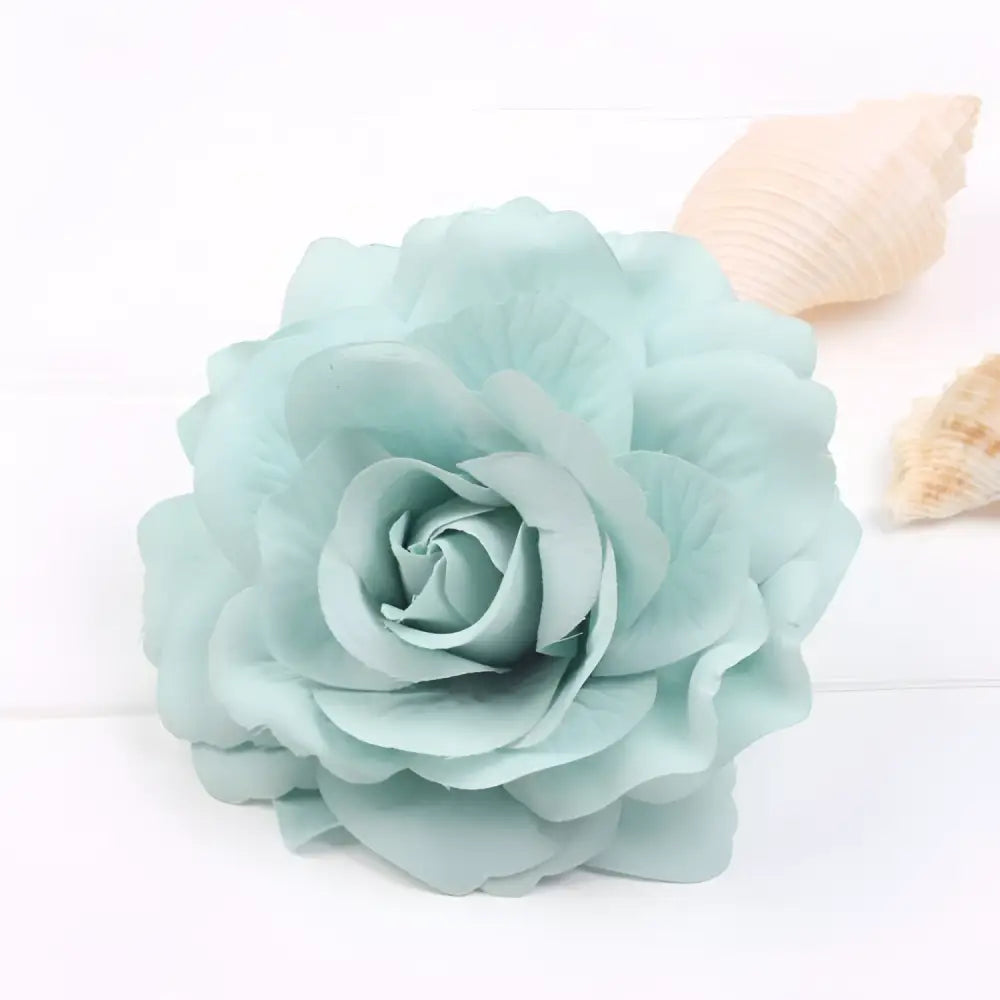 A delicate mint green artificial rose with soft layered petals on a multicolor red roses flocking cloth headdress hairpin