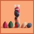 A set of multicolored beauty egg makeup sponges in hydrophilic polyurethane arranged around maange packaging tube