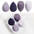 Set of four muted purple and gray hydrophilic polyurethane beauty egg makeup sponges in a clear plastic case