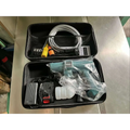 Teal and black multifunctional car wash pressure water gun in clear plastic wrap with battery pack and hose in carrying case
