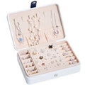 White multifunctional leather jewelry storage box with navy clasp beige compartments and built-in mirror for organizing necklaces and earrings