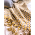 A cozy mustard yellow geometric knitted sofa blanket with soft tassels ideal for sofa cover and warmth