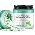 A clear glass jar with black lid containing light green oval nano hydroxyapatite toothpaste tablets by yecuce fluoride free