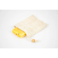 Beige textured mesh soap bag with wooden bead closure holding yellow soap bar in natural citrus bath body skincare set
