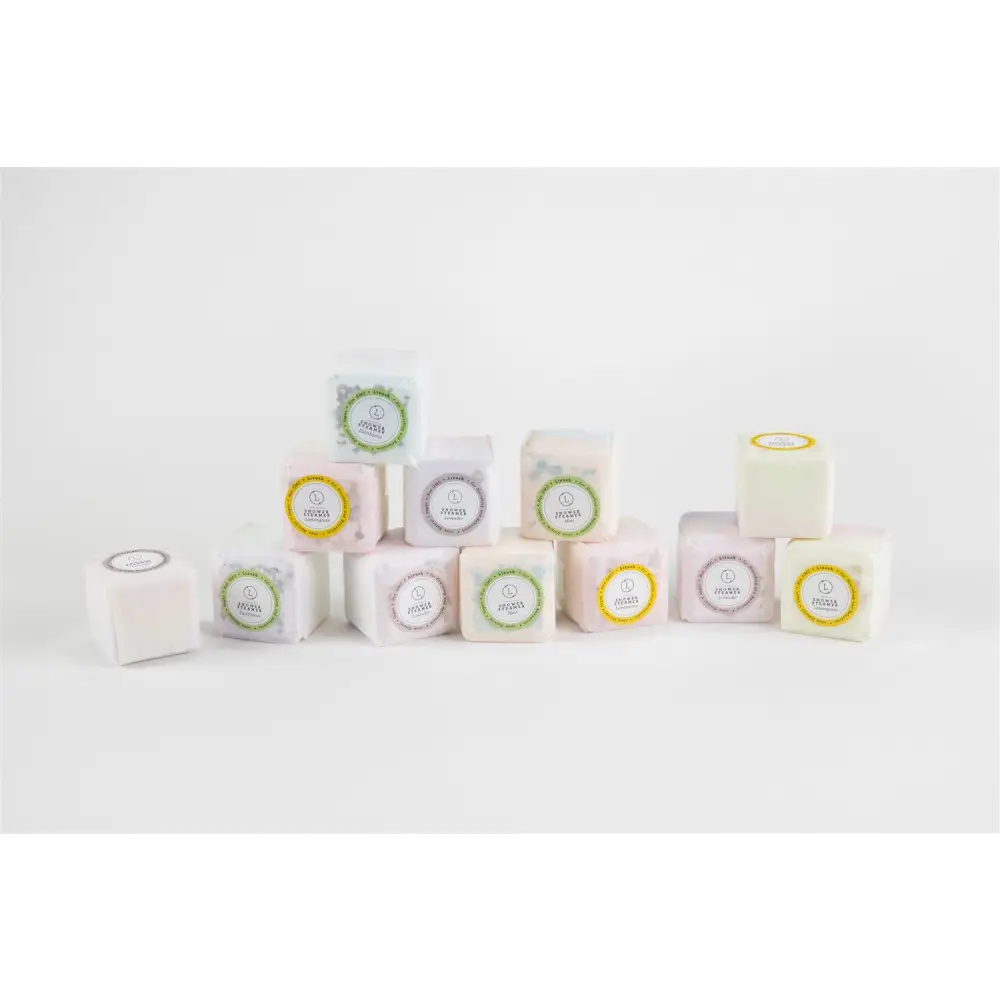 A natural citrus bath and body skincare set featuring pastel square shower steamers wrapped with jooss labels on white background