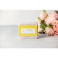A rectangular bar of pale off-white grapefruit soap with a bright yellow label in a natural citrus bath body skincare set