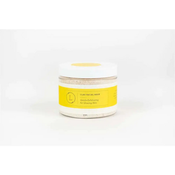A clear glass jar with a white lid and yellow label containing a natural clay mask for body skincare products and home spa