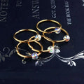 Gold-colored hoop earrings with iridescent faceted beads complement natural lycopose stone decorated bead hair ties