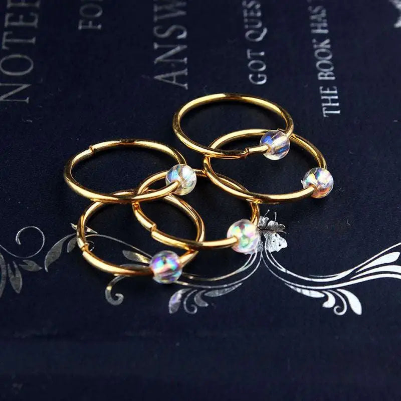 Gold-colored hoop earrings with iridescent faceted beads complement natural lycopose stone decorated bead hair ties