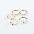 Gold-toned hoop earrings with single white pearl paired with natural lycopose stone decorated wood bead hair ties
