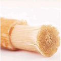A light brown wooden natural miswak tooth cleaning stick with visible wood grain and a frayed tip for effective cleaning