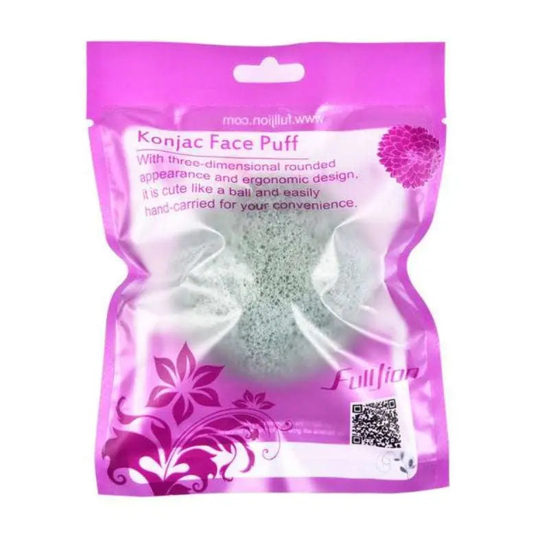 A light green round shap konjac sponge face cleaning puff in purple and white packaging for natural skincare