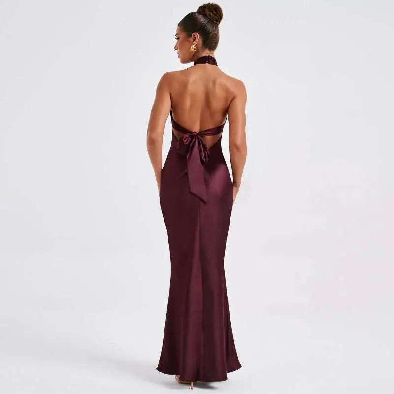 Sleek back view of a maroon elegant backless sleeveless satin gown with a fitted silhouette and tied bow at the waist