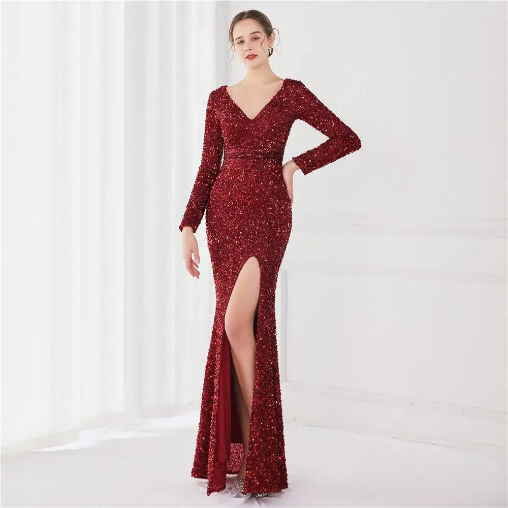A shimmering burgundy sequined evening dress with long sleeves and high slit for elegant occasions